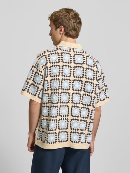 Männermodel trägt Strickshirt mit Polokragen und Knopfleiste von REVIEW, Baumwoll-Mix, Allover-Muster in Beige und Blau, Ganzkörperansicht Rückansicht