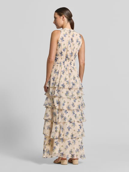 Frauenmodel trägt das Abendkleid im Stufen-Look Modell 'Marli' von Neo Noir mit floralem Muster, Chiffon-Textur, Ganzkörperansicht Rückansicht.