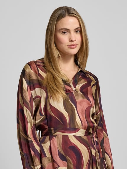 Frauenmodel trägt Minikleid aus Viskose mit Bindegürtel Modell 'Be44atricee' von ZABAIONE, abstraktes Muster, Nahaufnahme Oberkörper.