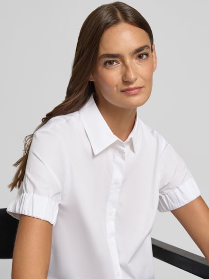 Frauenmodel trägt weiße Regular-Fit Kurzarmbluse aus reiner Baumwolle Modell 'EFFRY' von HUGO, Damen, Nahaufnahme Oberkörper.