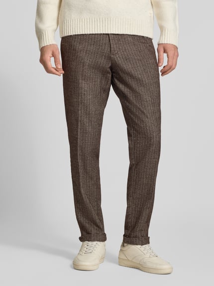 Männermodel trägt Regular Fit Hose mit Gesäßtaschen von JACK & JONES in Braun mit Bügelfaltenstruktur, Nahaufnahme Unterkörper.