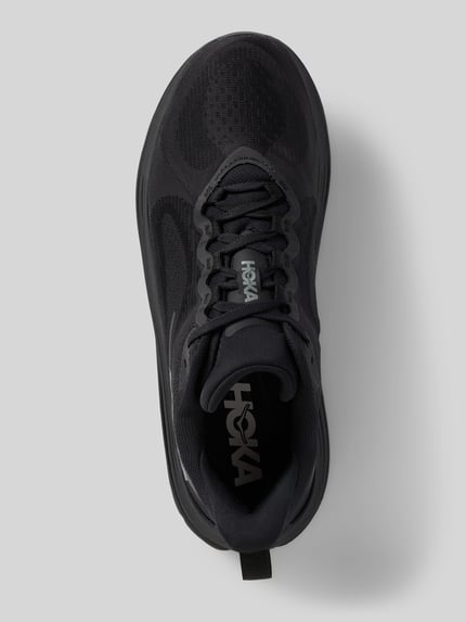 Produktfoto, ciemnoszare sneakersy z zaokrąglonym czubkiem i wiązaniem, model 'KAWANA 3' od HOKA z detalami z logo, wysokość obcasa w rozmiarze 44: 4 cm, wysokość cholewki w rozmiarze 44: 7 cm, szerokość w rozmiarze 44: 9 cm