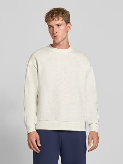 Męski model prezentuje Regular Fit Sweatshirt mit Baumwoll-Anteil od JACK & JONES, mieszanka bawełny, okrągły dekolt, krój regular fit, elastyczne wykończenia, długość tyłu 65 cm, rękawy 59 cm, jasnobeżowy, gładka tekstura, Ganzkörperansicht von vorne.