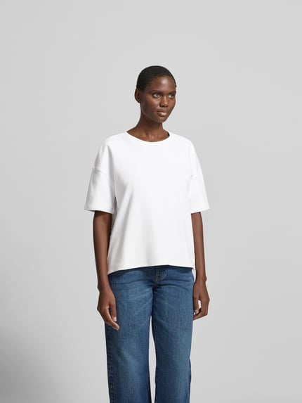 Modelka prezentuje Regular Fit T-Shirt aus Baumwoll-Mix od Juvia, biały kolor, okrągły dekolt, krótkie rękawy, przód, ujęcie całej sylwetki