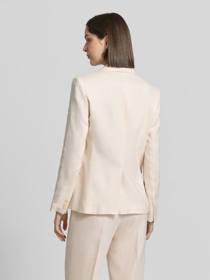 Frauenmodel trägt Blazer mit Pattentaschen Modell 'Boreli' von Mango aus Reine Baumwolle in Beige, taillierte Passform, Ganzkörperansicht Rückansicht. Rückenlänge bei Größe 36: 66 cm, Brustweite: 111 cm, Ärmellänge: 68 cm.