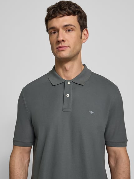 Männermodel draagt Regular Fit Poloshirt met labelstitching van Fynch-Hatton, puur katoen, polokraag, korte knoopsluiting, ruglengte maat M 74 cm, Nahaufnahme Oberkörper.
