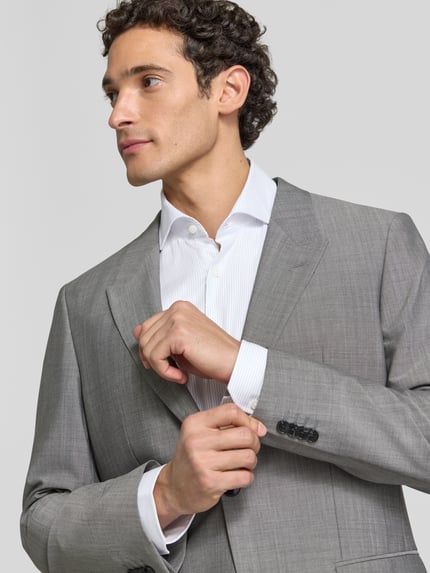 Männermodel trägt Regular Fit Businesshemd aus Wolle mit Kentkragen von BOSS, unifarben, gestreift, Ganzkörperansicht von vorne, Webware.
