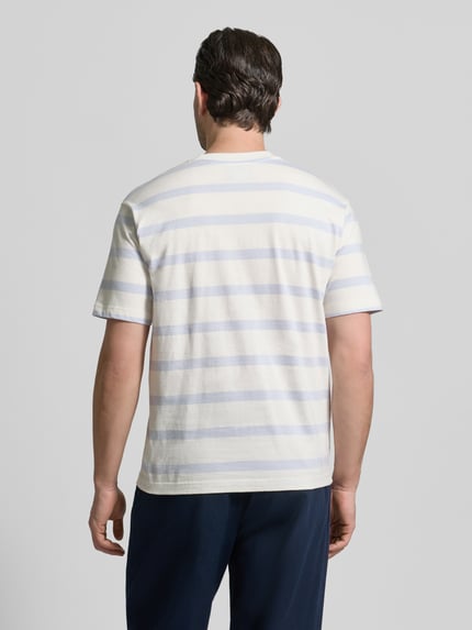 Männermodel trägt T-Shirt mit geripptem Rundhalsausschnitt von MCNEAL, Streifenmuster in Weiß und Hellgrau, Ganzkörperansicht Rückansicht.