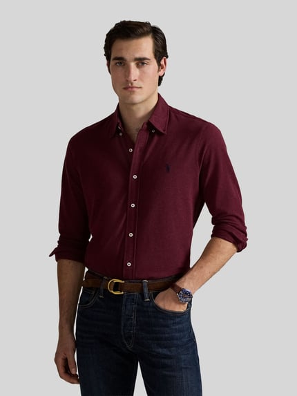 Męski model nosi Regular Fit Freizeithemd aus reiner Baumwolle von Polo Ralph Lauren w kolorze burgundowym, gładka tekstura, pełny widok z przodu.
