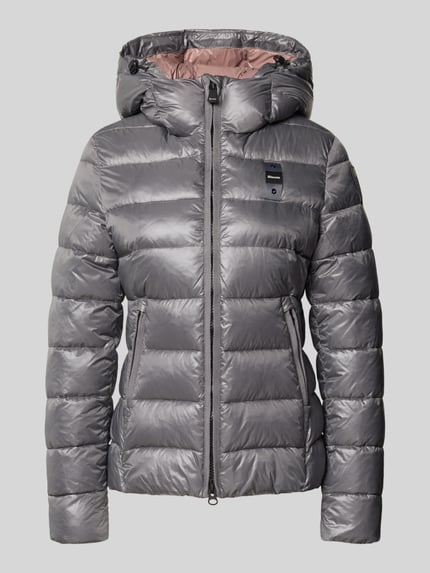 Produktfoto, silberne Jacke in Stepp-Optik Modell 'CAROLL' von Blauer USA mit Logo-Detail, Stehkragen und Kapuze auf grauem Hintergrund.
