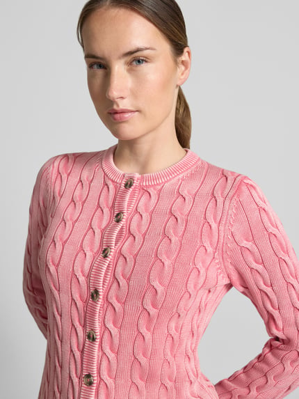 Frauenmodel trägt Relaxed Fit Strickjacke aus reiner Baumwolle von Jake*s Casual in Rosa, Zopfmuster, Nahaufnahme Oberkörper.
