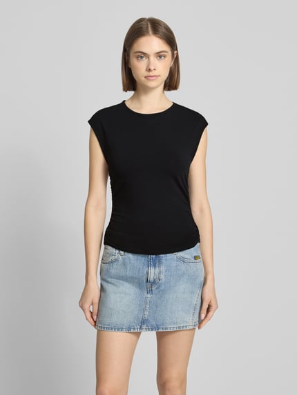 Frauenmodel trägt Slim Fit T-Shirt aus Baumwoll-Mix Modell 'MIRA' von Only, unifarben schwarz, kurze Ärmel, vorne, Ganzkörperansicht von vorne