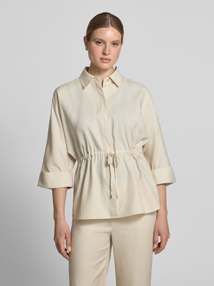 Frauenmodel trägt Relaxed Fit Bluse aus Lyocell-Mix mit 3/4-Arm von Comma, helle Farbe, Tunnelzug, Hemdblusenkragen, Ganzkörperansicht von vorne. Damen Bluse im Lyocell-Mix mit Leinen-Anteil, Rückenlänge 71 cm, Ärmellänge 58 cm, glatte Textur.
