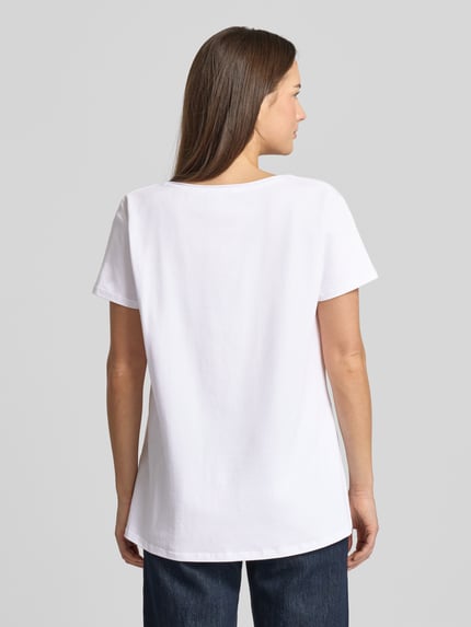 Frauenmodel trägt weißes Relaxed Fit T-Shirt mit Pailettenbesatz Modell 'Martinis Manolos' von miss goodlife, Rückenansicht, Ganzkörperansicht Rückansicht.