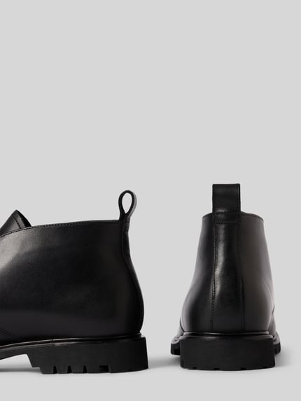 Produktfoto, schwarze Schuhe aus echtem Leder Modell 'VENTON' von LLOYD, abgerundete Form, profilierte Sohle, Schnürverschluss, strukturierte Oberfläche, Absatzhöhe 3 cm, Schafthöhe und -weite 11 cm, neutraler Hintergrund.