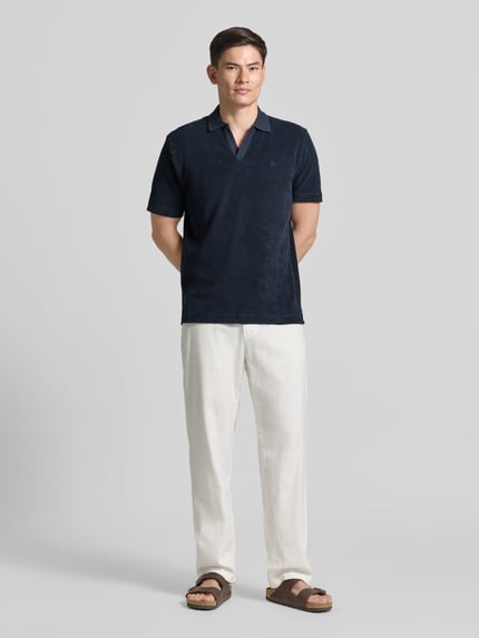 Mężczyzna nosi Regular Fit Poloshirt aus reinem Baumwoll-Frottee od Marc O'Polo, koszulka polo z granatowej froty, gładka faktura, Ganzkörperansicht von vorne.