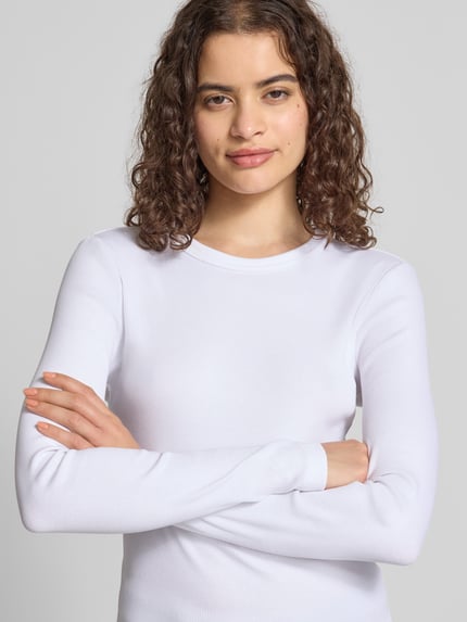 Frauenmodel trägt Slim Fit Langarmshirt aus Baumwoll-Mix Modell 'VAL' von ONLY, weiß, dezente Struktur, Damen Langarmshirt, Nahaufnahme Oberkörper.