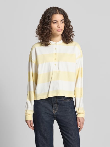 Vrouwenmodel draagt Relaxed Fit Sweatshirt met Logo-Stitching model 'Varsity' van Calvin Klein Jeans, katoen, lang, lichtgeel-wit, knoopsluiting, elastische mouwuiteinden, vooraanzicht buste-hoogte.