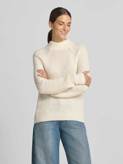 Frauenmodel trägt Strickpullover aus Kaschmir-Baumwoll-Mix Modell 'LONA' von 0039 Italy, cremefarben, strukturierte Oberfläche, Ganzkörperansicht von vorne, Damen Regular Fit mit Stehkragen, Rückenlänge 60 cm, Ärmellänge 78 cm.