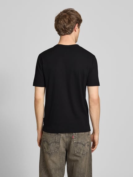 Männermodel trägt Regular Fit T-Shirt aus Baumwoll-Mix von Marc O'Polo Denim in Schwarz, unifarben, Kurzarm, Ganzkörperansicht Rückansicht.