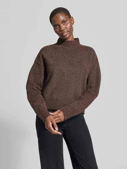 Frauenmodel trägt Turtleneck-Pullover mit Woll-Anteil und Rundhalsausschnitt von Neo Noir, braune Farbe, gerader Schnitt, ganzkörperansicht von vorne.