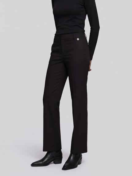 Frauenmodel trägt Regular Fit Hose mit Bundfalten Fenja2-780 von Stehmann, Wide Leg, unifarben schwarz, Webware, Ganzkörperansicht von vorne.