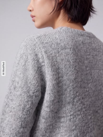 Frauenmodel trägt Regular Fit Strickjacke mit Woll-Anteil Modell 'NOVAH' von VERO MODA, graue melierte Struktur, Nahaufnahme Rückenansicht, KI-modifiziertes Bild.