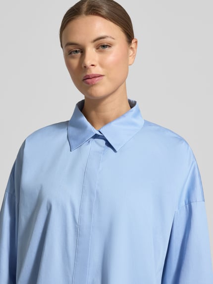 Frauenmodel trägt hellblaue Hemdbluse mit Hemdblusenkragen und verdeckter Knopfleiste Modell 'Fundra' von OPUS, Reine Baumwolle, Lockerer-Schnitt, Nahaufnahme Oberkörper.