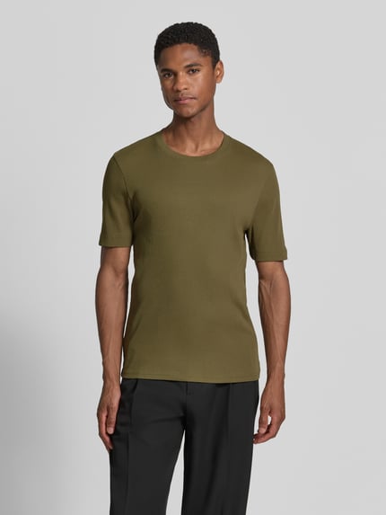Männermodel draagt Slim Fit T-shirt met ronde hals model 'ENIL' van Drykorn van puur katoen, fijnrib, heren, olijfgroen, maat M ruglengte 67 cm, voorkant volledige lichaamsweergave.