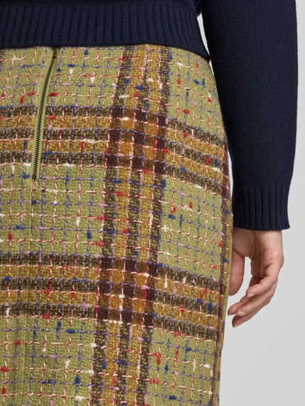 Frauenmodel trägt Minirock im Allover-Look mit Reißverschluss von Christian Berg Woman, grüne und braune Karomuster, Material-Mix, Nahaufnahme Hüfte, Baumwoll-Anteil.