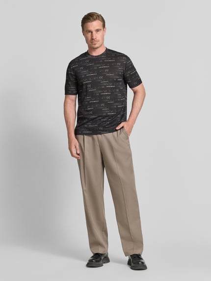 Männermodel trägt T-Shirt mit Logo-Muster und Rundhalsausschnitt von Emporio Armani, Lyocell-Baumwoll-Mix, Regular-Fit, Herren, Ganzkörperansicht von vorne.