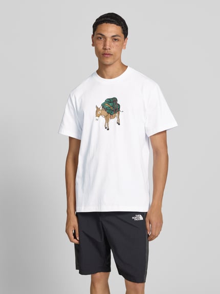 Mannenmodel draagt T-shirt met motiefprint model 'DONKEY TAXI' van The North Face, puur katoen, regular fit, ronde hals, ruglengte maat M 70 cm, motiefprint en logoprint op de rug, Ganzkörperansicht von vorne.