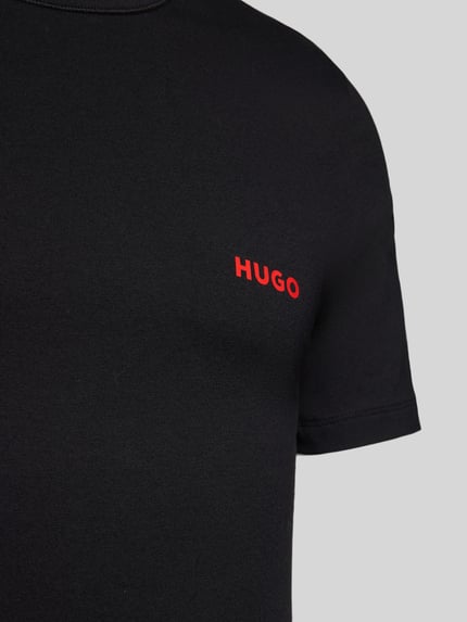 Männermodel trägt T-Shirt mit Label-Print im 3er-Pack von HUGO in Schwarz, reine Baumwolle, Unifarbenes-Design, Nahaufnahme Oberkörper.