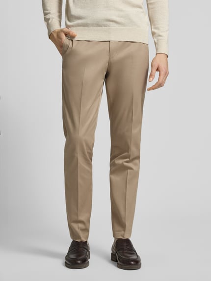 Männermodel trägt Stoffhose mit Gesäßtaschen Modell 'Tenuta' von Tiger Of Sweden, gerader Schnitt, Nahaufnahme Oberkörper bis Schuhe.