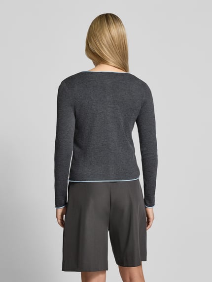 Frauenmodel trägt dunkelgraue Strickjacke mit Rundhalsausschnitt Modell 'LUCCAPK' von MANGO, Material-Mix, Slim Fit, Ganzkörperansicht Rückansicht.