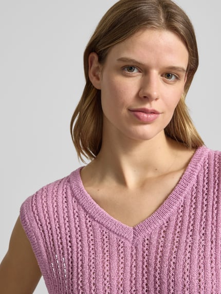 Kobiece modelka nosi top in strick-optik od Review w kolorze różowym, haft angielski, dekolt w serek, imitacja dzianiny, zbliżenie na górną część ciała.