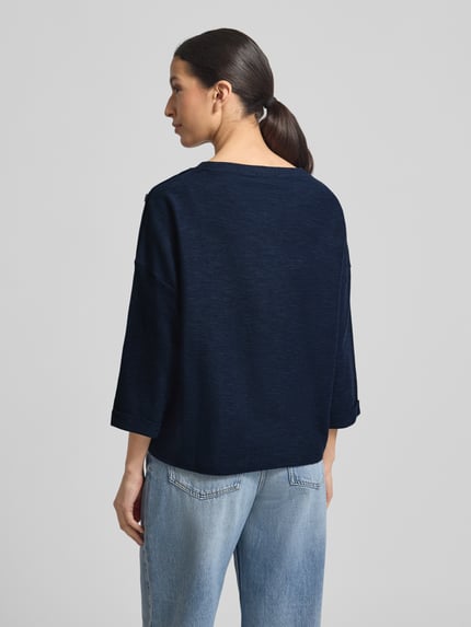 Frauenmodel trägt Loose Fit 3/4-Shirt aus Baumwoll-Mix mit Modal-Anteil von Tom Tailor in Dunkelblau, Piqué-Struktur, Rückansicht.