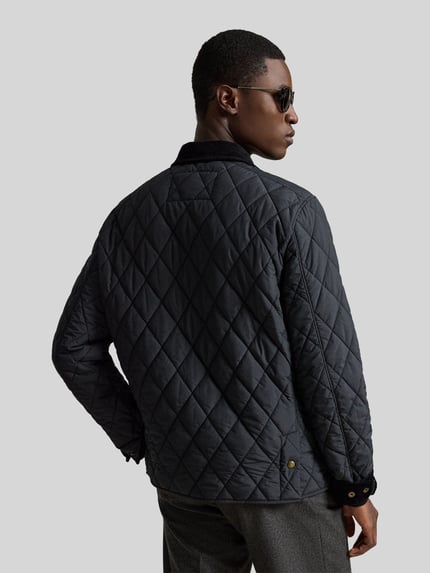 Männermodel trägt Regular Fit Steppjacke mit Druckknopfleiste von Polo Ralph Lauren, jednokolorowy, wykładany kołnierz, długi rękaw, wyhaftowane logo, kieszenie z patką i kieszeń wewnętrzna, wykończenie: pikowana tkanina, Ganzkörperansicht Rückansicht