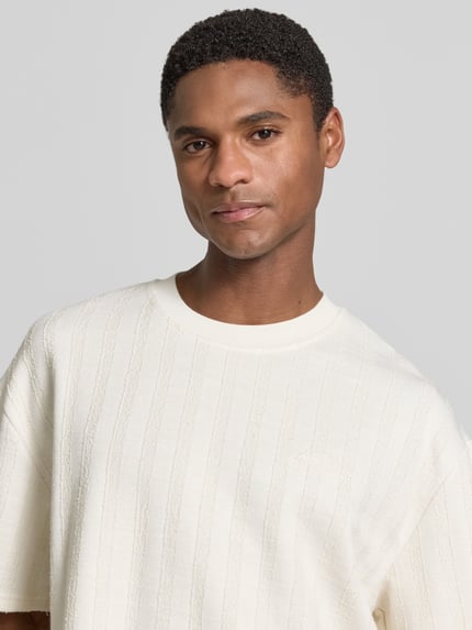 Männermodel trägt T-Shirt mit Strukturmuster und Rundhalsausschnitt von Les Deux, Material-Mix mit Viskose-Anteil, Regular-Fit, Nahaufnahme Oberkörper.