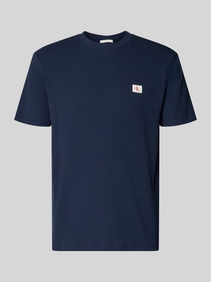 Produktfoto, Regular Fit T-Shirt mit Logo-Patch von Calvin Klein Jeans aus Baumwoll-Mix, dunkelblau mit Strukturmuster und Rundhalsausschnitt.