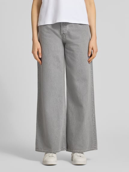 Frauenmodel trägt Wide Leg Jeans aus Lyocell-Baumwoll-Mix Modell 'ASTRAEAAS' von Armedangels in grauer Denim-Optik, 5-Pocket-Design, Mid Waist, Ganzkörperansicht von vorne.