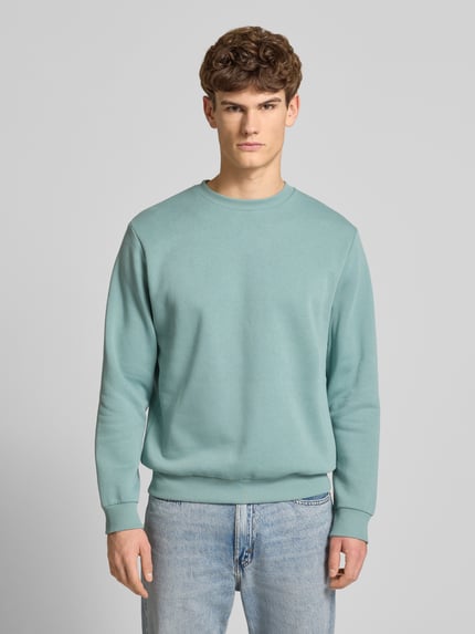 Männermodel trägt Sweatshirt mit gerippten Abschlüssen Modell 'BRADLEY' von Jack & Jones, Regular Fit, Rundhalsausschnitt, Material-Mix, Ganzkörperansicht von vorne.