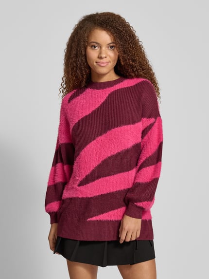 Frauenmodel trägt Loose Fit Strickpullover mit Rundhalsausschnitt Modell 'BLAIR' von Noisy May in Pink und Dunkelrot, Allover-Look, Ganzkörperansicht von vorne.