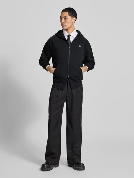Männermodel trägt Sweatjacke mit Kapuze von Moose Knuckles in Schwarz, lockerer Schnitt, Baumwoll-Mix, Label-Detail, Ganzkörperansicht von vorne.