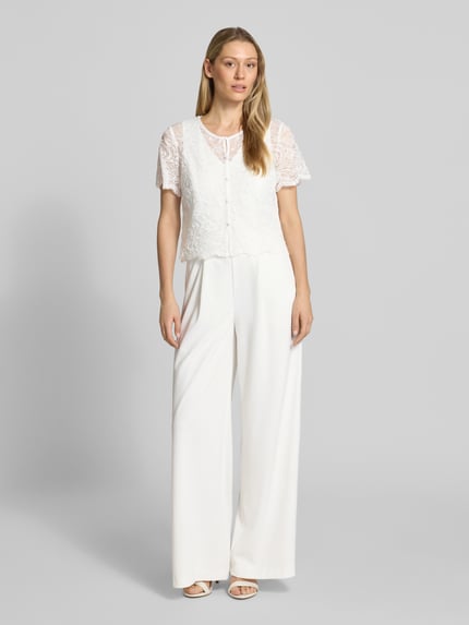 Kobiece model prezentuje Regular Fit Jumpsuit mit Spitzenbesatz od Vera Mont, biały, elastyczna mieszanka materiałów, cekinowe obszycie, krótki rękaw, listwa guzikowa, okrągły dekolt, krój regular fit, całkowita długość 157 cm, długość wewnętrzna nogawki 81 cm, Ganzkörperansicht von vorne.