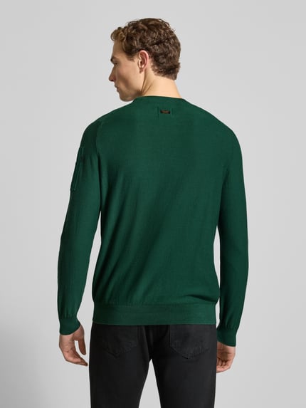 Männermodel trägt grünen Strickpullover mit Label-Detail von PME Legend, reine Baumwolle, gerippte Abschlüsse, Rückansicht Ganzkörperansicht.