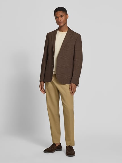Männermodel trägt Slim Fit 2-Knopf-Sakko aus Leinen-Baumwoll-Mix von bugatti in Braun mit Strukturmuster, ganzkörperansicht von vorne.