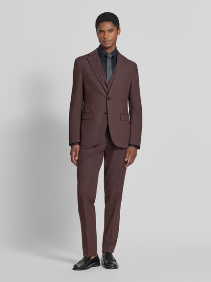Männermodel trägt Slim Fit Sakko mit Viskose-Anteil von MCNEAL in Braun, 2-Knopf-Verschluss, Reverskragen, Ganzkörperansicht von vorne.