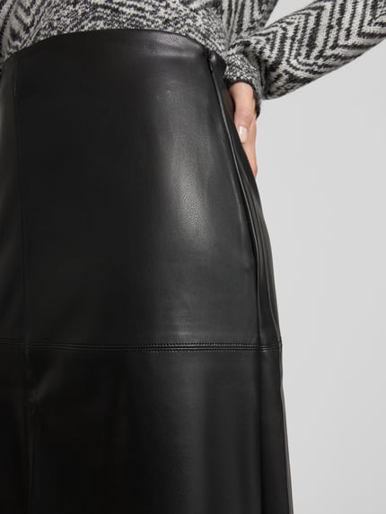 Vrouwenmodel draagt Ausgestellter Midi-Rock in Glattleder-Optik van s.Oliver BLACK LABEL, zwart, glad oppervlak, detailopname heup.