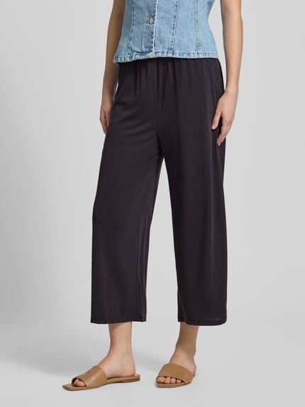 Vrouwenmodel draagt Regular Fit Culotte uit viscosemix model 'HANNAH' van Only, look: effen, pasvorm: regular fit, boord: elastisch, zijzakken, materiaalverwerking: sweat, materiaal: viscosemix, driekwartlengte, donkere tinten, zachte textuur. Detailopname onderlichaam.